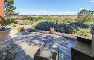 a patio with a view of the desert from a house at 5 Bedroom Beautiful Home In Ouveillan in Ouveillan