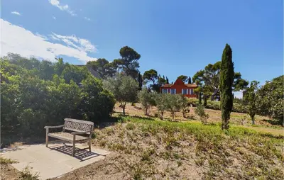 a bench sitting on a sidewalk in a field at 5 Bedroom Beautiful Home In Ouveillan in Ouveillan