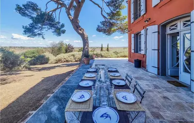 a long wooden table with plates of food on it at 5 Bedroom Beautiful Home In Ouveillan in Ouveillan