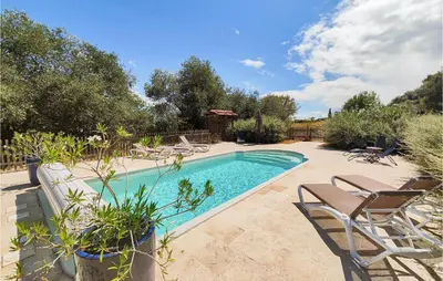 a swimming pool with chairs and a table at 5 Bedroom Beautiful Home In Ouveillan in Ouveillan