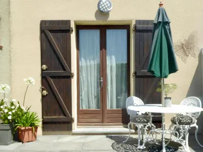 a patio with a door and a table and an umbrella at Apartment The Address in Carcassonne