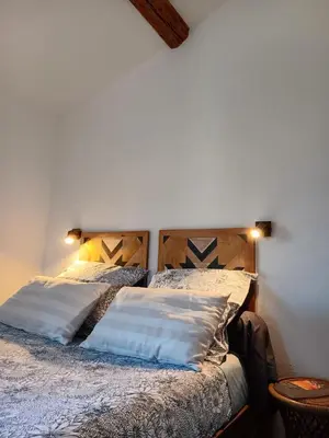 a bedroom with two beds and two lamps on the wall at La Petite Romance - Gîte 3 étoiles in Siran