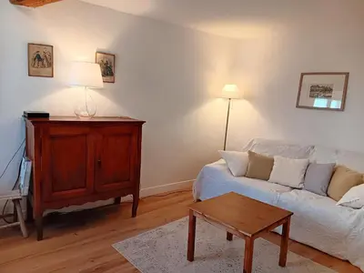 a living room with a white couch and a table at La Petite Romance - Gîte 3 étoiles in Siran