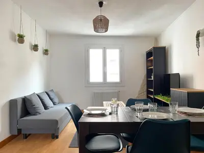 a living room with a table and a couch at Duplex calme & fonctionnel - Centre Narbonne - Idéal déplacements pro in Narbonne