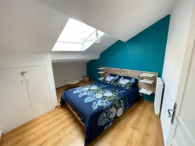 a bedroom with a bed with a blue wall at Duplex calme & fonctionnel - Centre Narbonne - Idéal déplacements pro in Narbonne