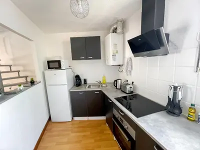 a small kitchen with a white refrigerator and a sink at Duplex calme & fonctionnel - Centre Narbonne - Idéal déplacements pro in Narbonne