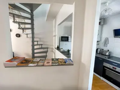 a room with books on a shelf in a kitchen at Duplex calme & fonctionnel - Centre Narbonne - Idéal déplacements pro in Narbonne