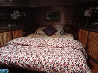 a large bed in a bedroom with a comforter at Bateau de pirates in Gruissan
