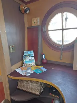 a table with books on it in a room with a window at Bateau de pirates in Gruissan