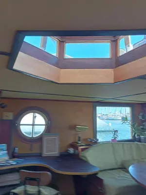 a living room with a couch and windows on a boat at Bateau de pirates in Gruissan