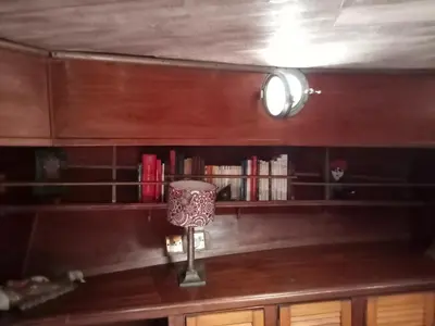 a book shelf with a lamp on a wooden table at Bateau de pirates in Gruissan