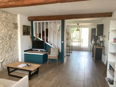 a living room with a television and a table at La maison de Marie - Jardin arboré - Garage privatif - Netflix in Carcassonne