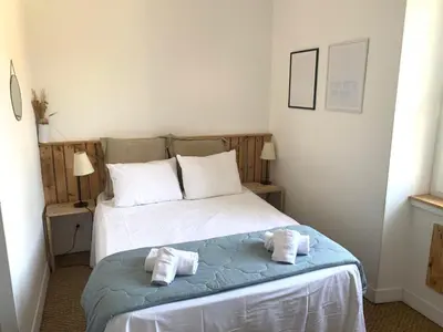 a bedroom with a bed with towels on it at La maison de Marie - Jardin arboré - Garage privatif - Netflix in Carcassonne