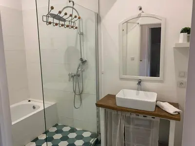 a white bathroom with a sink and a shower at La maison de Marie - Jardin arboré - Garage privatif - Netflix in Carcassonne