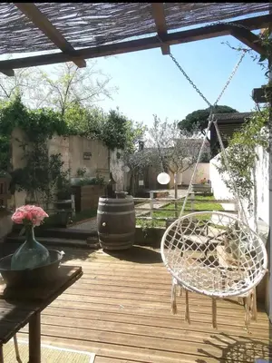 a patio with two chairs and a swing at La maison de Marie - Jardin arboré - Garage privatif - Netflix in Carcassonne