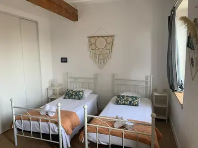 two twin beds in a room with white walls at La maison de Marie - Jardin arboré - Garage privatif - Netflix in Carcassonne