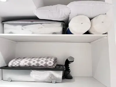 a white closet with white shelves and pillows at Salut Le Petit Gite in Carcassonne