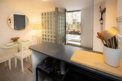 a kitchen with a counter top and a table at Salut Le Petit Gite in Carcassonne