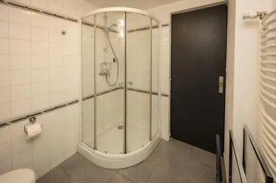 a shower with a glass door in a bathroom at Salut Le Petit Gite in Carcassonne