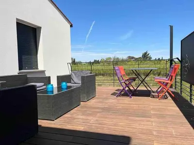 a patio with chairs and a table on a deck at Tierra Del Viento - Villa Proche de la Mer in Peyriac-de-Mer