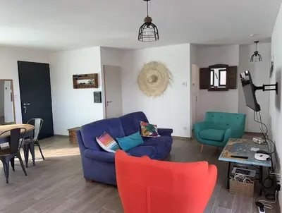 a living room with a blue couch and a table at Tierra Del Viento - Villa Proche de la Mer in Peyriac-de-Mer
