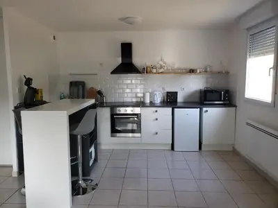 a kitchen with white appliances and a tile floor at les lys magiques in Carcassonne