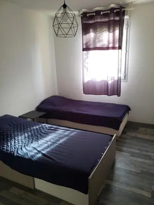 two beds in a small room with a window at les lys magiques in Carcassonne