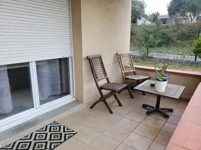 two chairs and a table on a porch at les lys magiques in Carcassonne