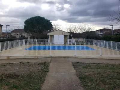 a fence in front of a swimming pool at les lys magiques in Carcassonne