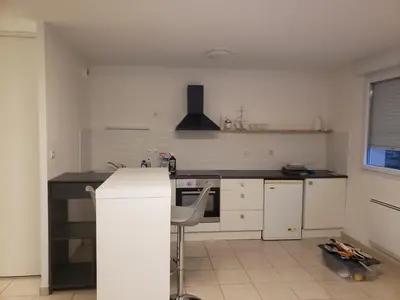 a kitchen with white cabinets and a stove top oven at les lys magiques in Carcassonne