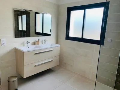 a bathroom with a sink and a glass shower at La Maison Louis - moderne & familiale in Lapalme