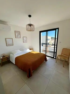 a bedroom with a large bed and a window at La Maison Louis - moderne & familiale in Lapalme