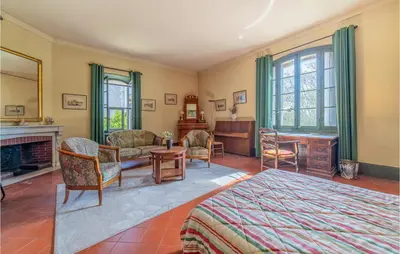 a bedroom with a bed and a desk and a fireplace at Amazing Home In Lézignan-Corbières in Lézignan-Corbières