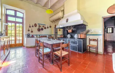 a kitchen with a table and chairs and a stove at Amazing Home In Lézignan-Corbières in Lézignan-Corbières