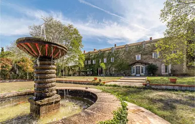 a fountain in front of a large building at Amazing Home In Lézignan-Corbières in Lézignan-Corbières