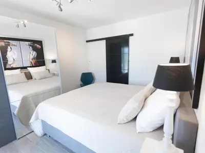 a white bedroom with two beds and a lamp at Luna in Aigne