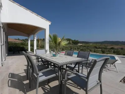 a patio with a table and chairs and a pool at Luna in Aigne