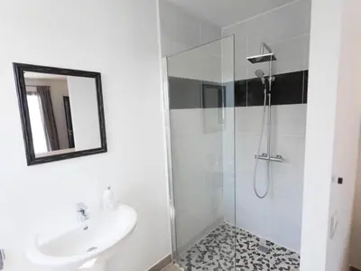 a white bathroom with a sink and a shower at Luna in Aigne