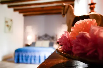 a bowl of pink flowers sitting on a wooden table at Chambres d'Hôtes Domaine du Hameau Baylesse in Saint-Jean-dʼAigues-Vives