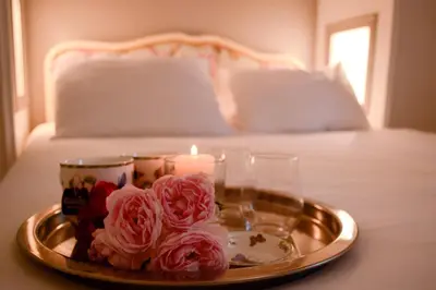 a tray with flowers and candles on a bed at Chambres d'Hôtes Domaine du Hameau Baylesse in Saint-Jean-dʼAigues-Vives