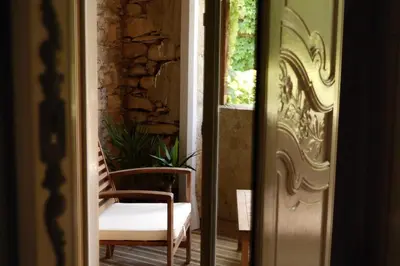 a door leading to a porch with a chair and a plant at Chambres d'Hôtes Domaine du Hameau Baylesse in Saint-Jean-dʼAigues-Vives