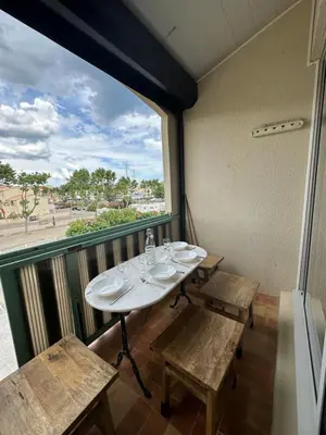 a room with a table and benches and a window at La Mezza de Gruissan in Gruissan