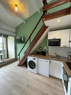 a kitchen with a washing machine and a staircase at La Mezza de Gruissan in Gruissan