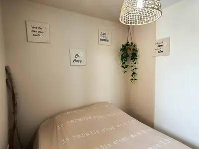 a corner of a room with a bed and signs on the wall at Au bord de la plage du Grazel in Gruissan