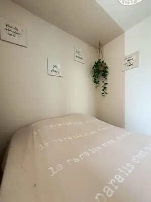 a bedroom with a white bed with signs on the wall at Au bord de la plage du Grazel in Gruissan