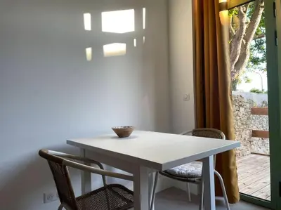 a white table and chairs in a room with a window at Studio - Centre de Villefranche de Lauragais in Villefranche-de-Lauragais
