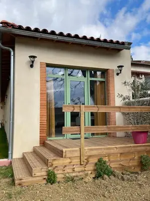 a house with a wooden deck with a window at Studio - Centre de Villefranche de Lauragais in Villefranche-de-Lauragais