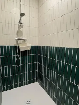 a green and white tiled bathroom with a sink at Studio - Centre de Villefranche de Lauragais in Villefranche-de-Lauragais