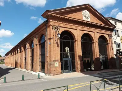 a brick building with a clock on top of it at Studio - Centre de Villefranche de Lauragais in Villefranche-de-Lauragais