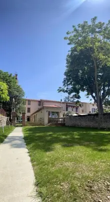 a house with a yard with a tree and a sidewalk at Studio - Centre de Villefranche de Lauragais in Villefranche-de-Lauragais